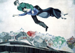 Over the Town, by Marc Chagall, Marc in green holds Bella in blue as they soar over a town of peaked roofs and fences yards with a tiny goat in one.