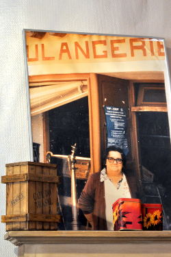  Historic photo of Odette Gulini, the baker's wife in Roussillon, standing behind her counter