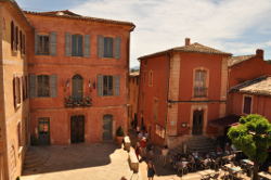 photo of La Mairie, the town hall of Roussillon, Provence, in coral-colored stucco and stone.