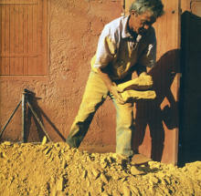 An ochre worker moving slabs of yellow ochre, the same color as his dusty clothing