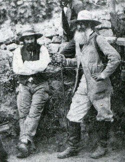 Historic photo of Pissarro and Cezanne, both bearded, both wearing slouch hats, standing, black and white.
