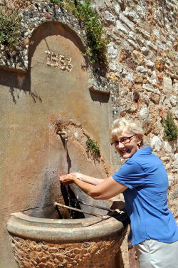 Susan Vreeland washing her hands after a delicious lunch in place de la Mairie, Roussillon: Photo Copyright Marcia M. Mueller