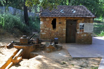 Pipe and canal for ochre slurry in front of one of the buildings of the Matthieu Ochre Works: Photo Copyright Marcia M. Mueller